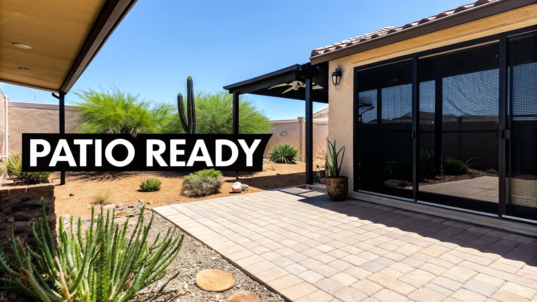 A spacious desert-style outdoor patio with pavers, a covered area, and sliding screen doors.